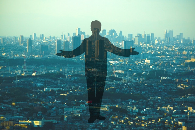 都会のビルの背景と人物のシルエット